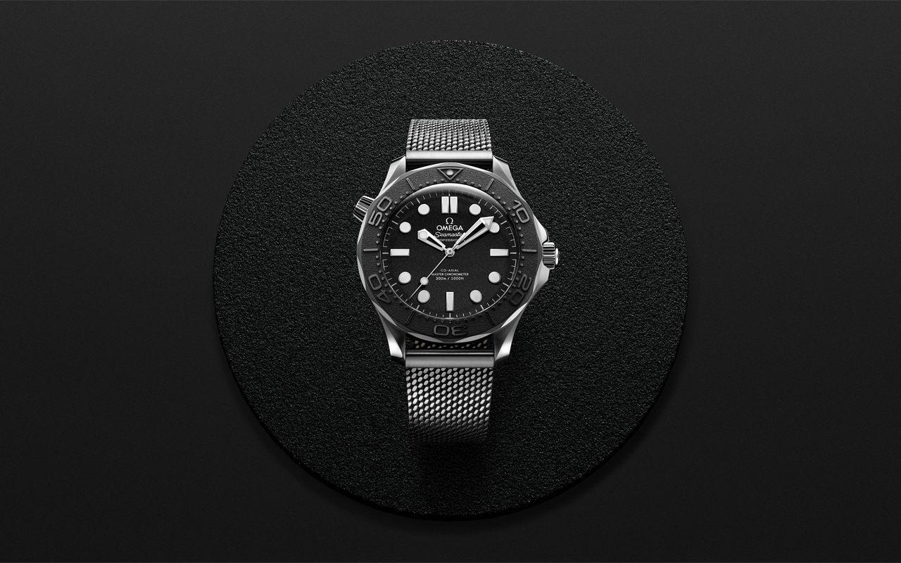 Seamaster Diver 300M Édition Spectre sur bracelet milanais, posée sur un disque noir grainé