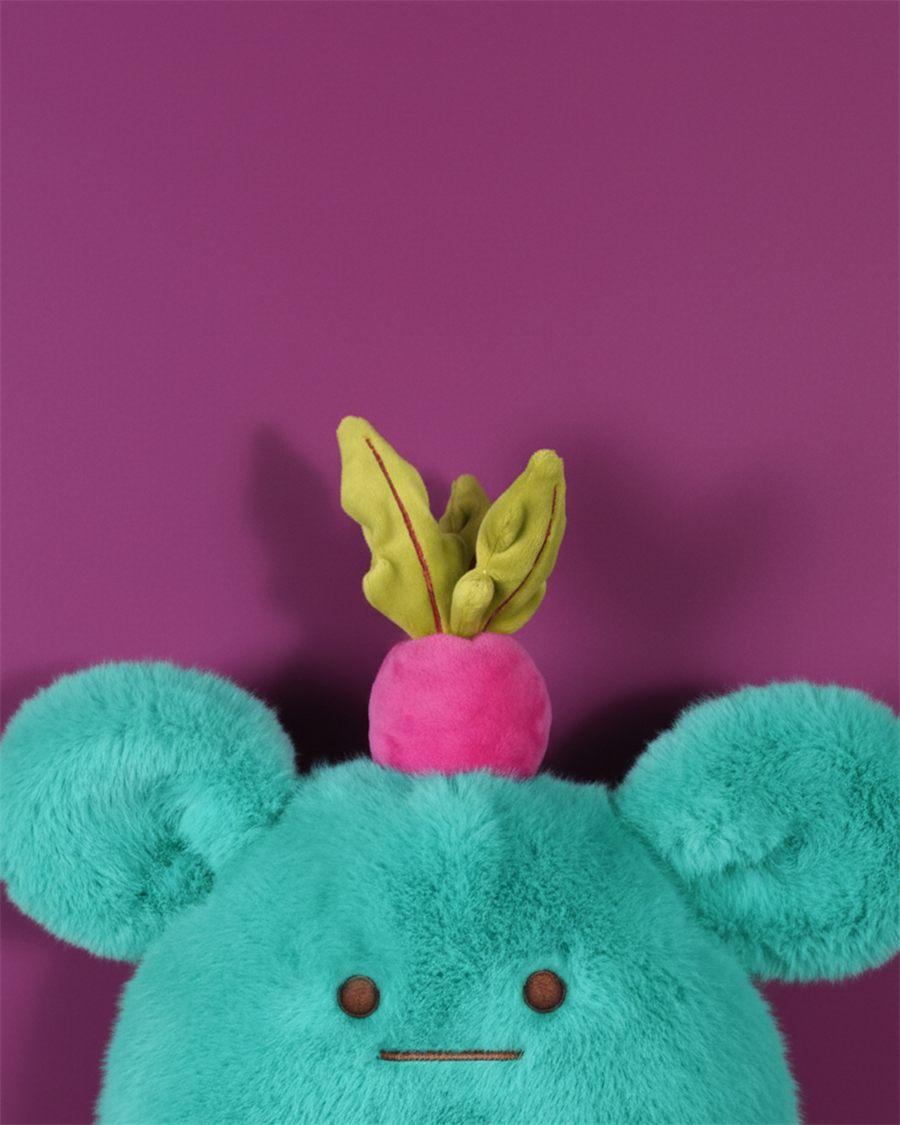 Gros plan sur la peluche MIAM Billie Radish, bleu océan, son radis rose posé sur la tête