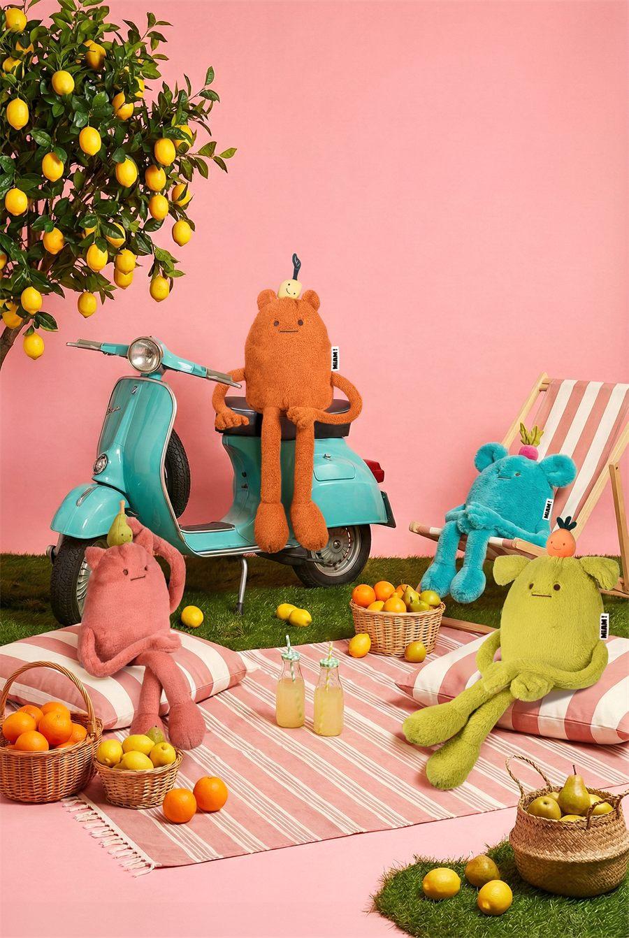 Les peluches MIAM Britney Pear, John Lemon, Billie Radish et Laurent Jade réunies autour d'un scooter bleu