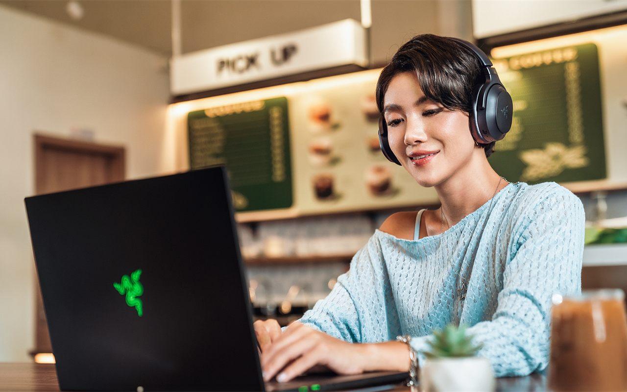 Une utilisatrice porte le casque Razer Barracuda V2 Pro dans un café