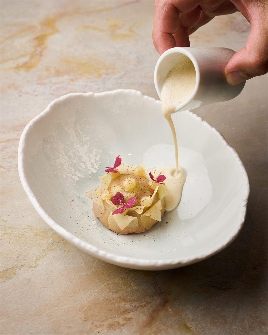 Sauce glacée à la poire versée sur le dôme poire-chocolat du restaurant Aldéhyde