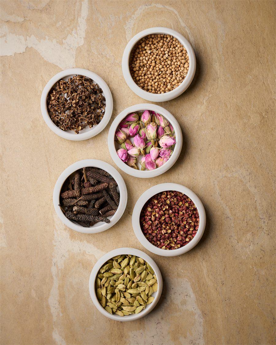 Coupelles de fleurs et d'épices, dont la rose, le poivre long et la cardamome