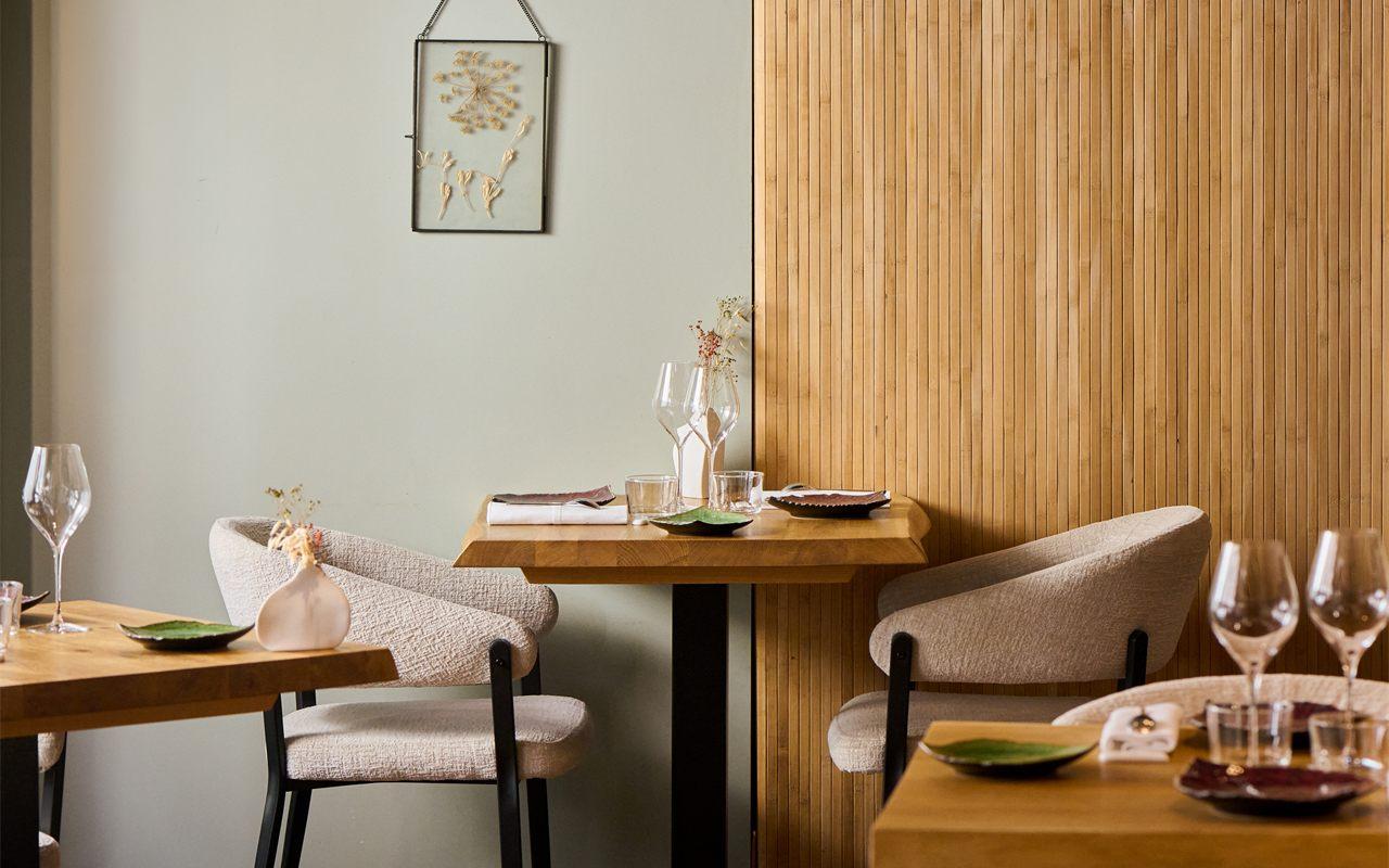 Tables dressées devant les murs vert d'eau et les panneaux de bois d'Aldéhyde