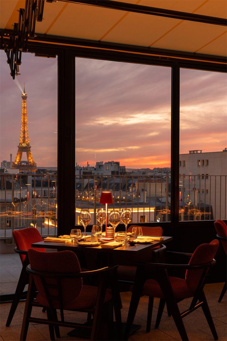 Une table d'Aqua Kyoto Paris face à la tour Eiffel au coucher du soleil