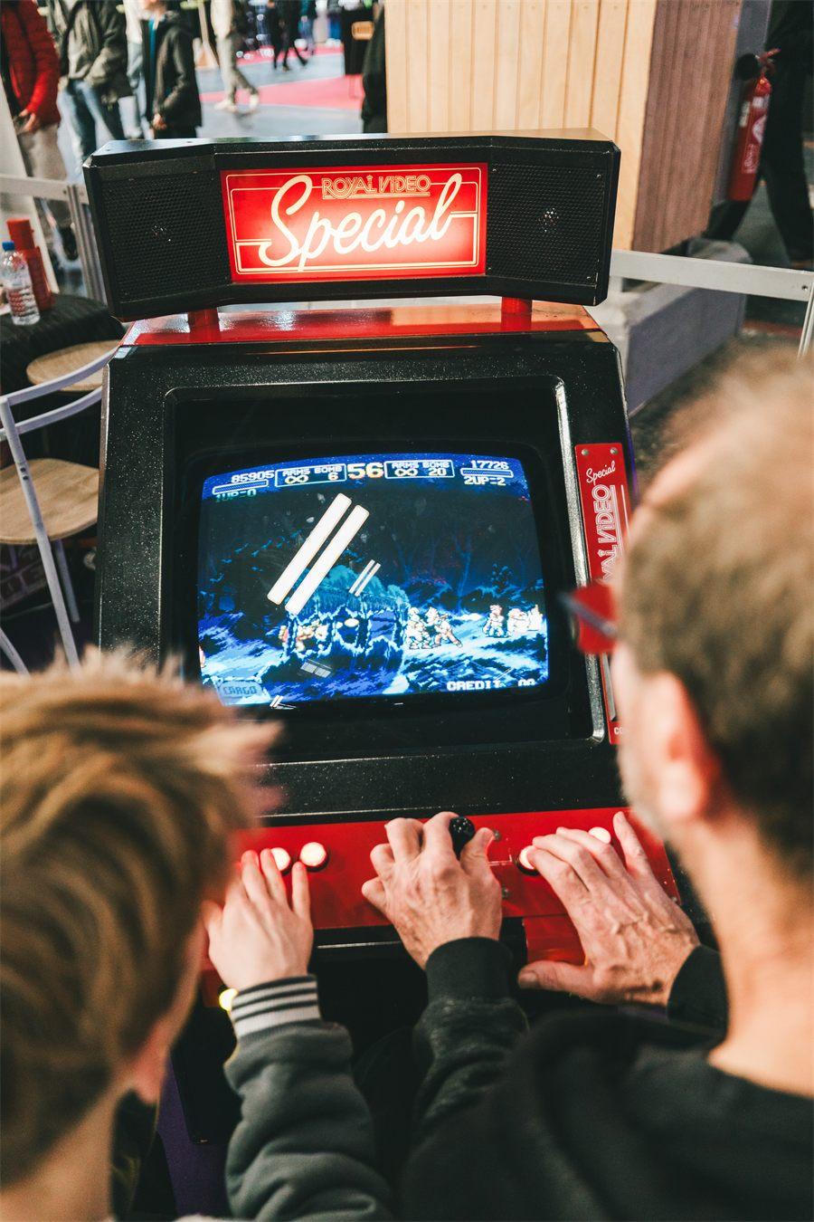 Visiteurs aux commandes d'une borne d'arcade rétro à la Paris Games Week 2025