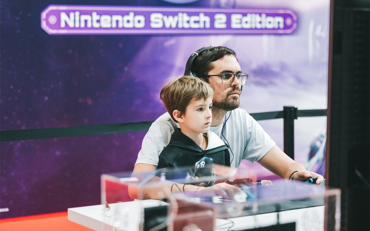 Un père et son fils jouent sur le stand Nintendo Switch 2 de la Paris Games Week 2025