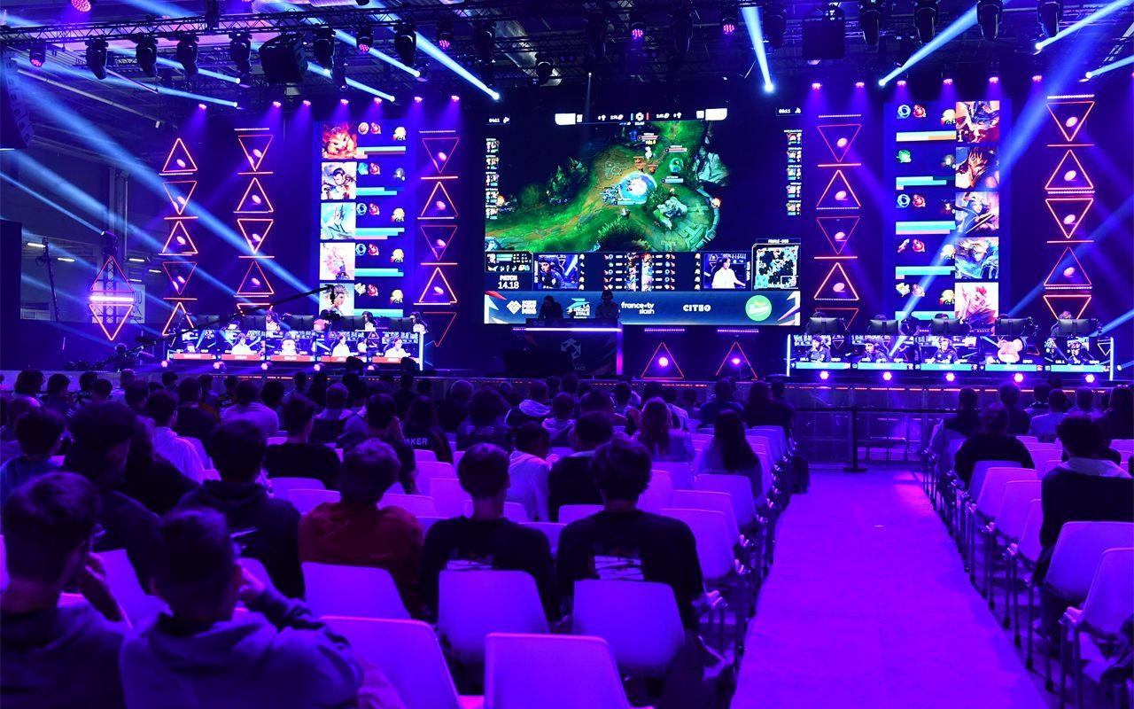 Scène esport de la Paris Games Week sous les projecteurs violets, devant le public