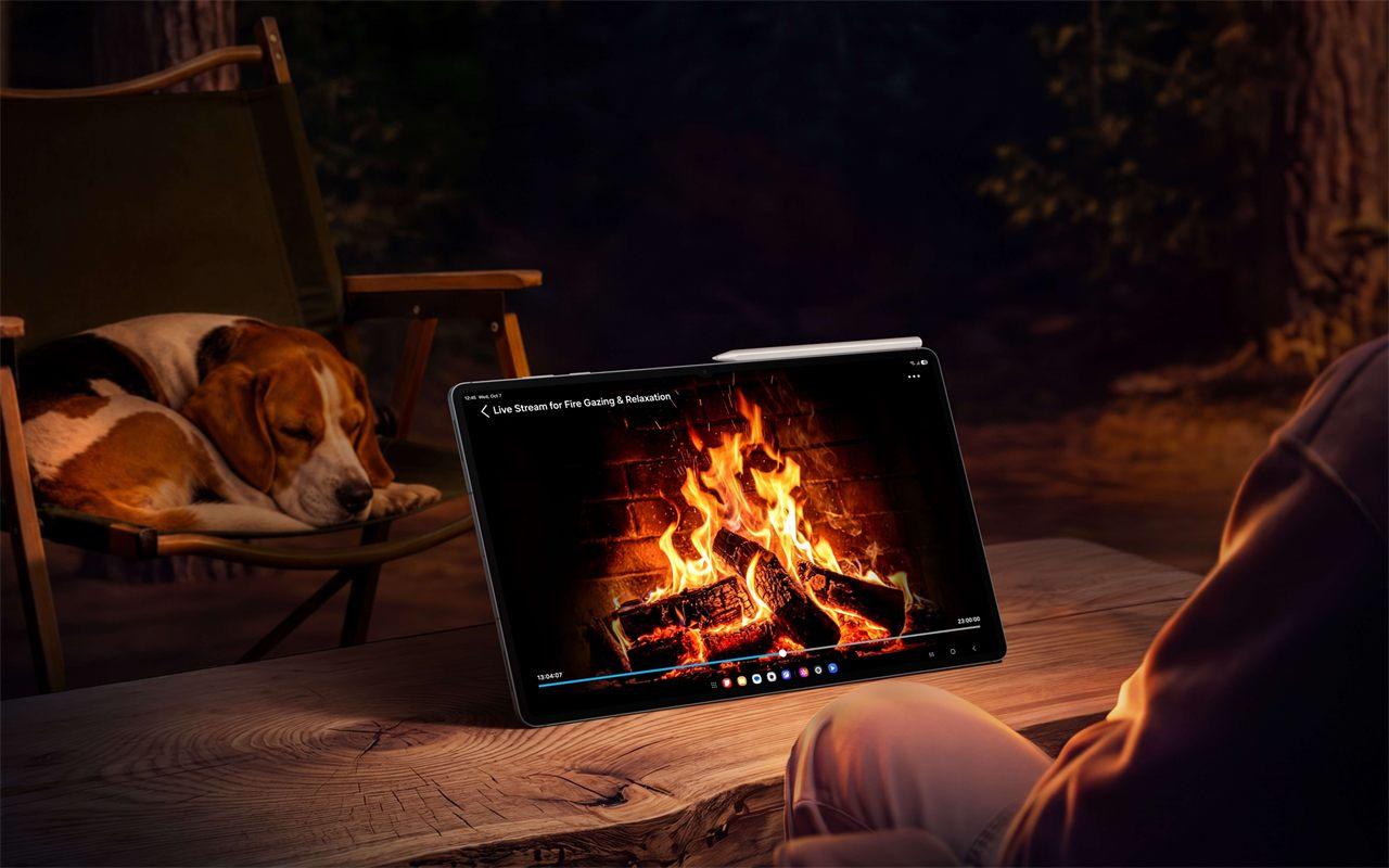 Une vidéo de feu de cheminée sur la Galaxy Tab S12 Ultra, posée sur une table de bois en forêt, la nuit