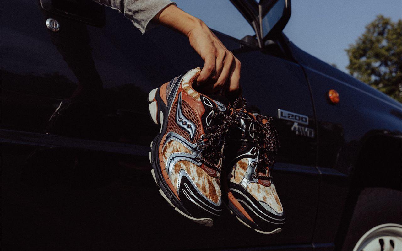 Une paire de ProGrid Triumph 4 Space Cowboy tenue à la main contre un pick-up noir