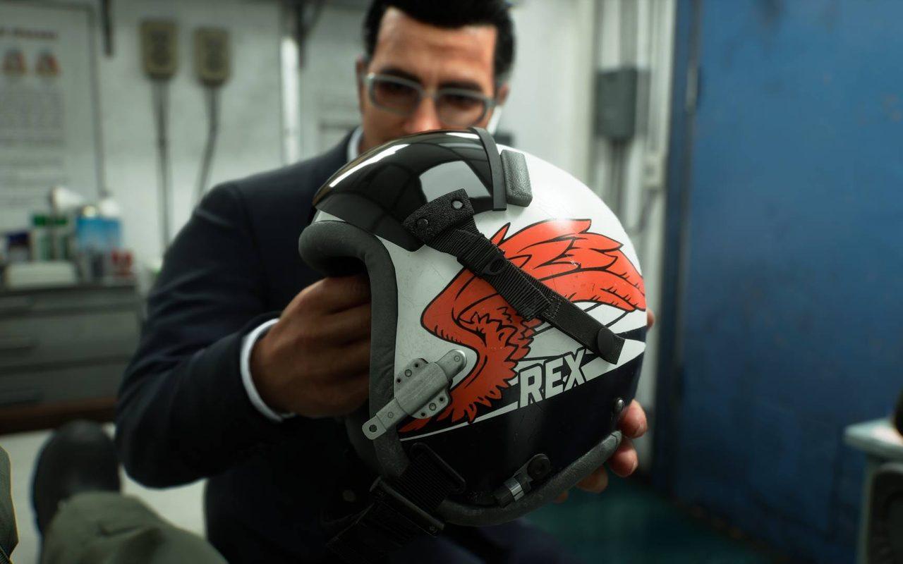 Un homme en costume tient le casque de pilote frappé du nom Rex