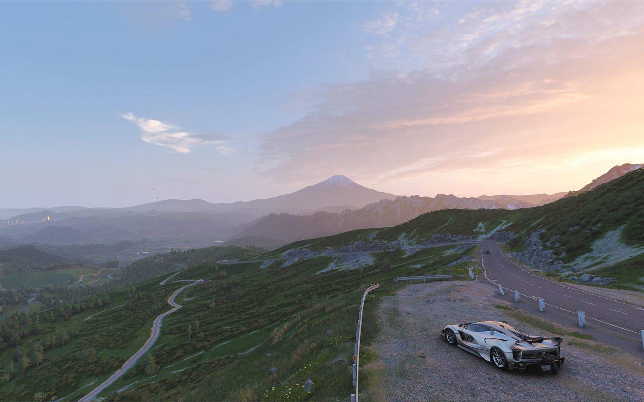 Supercar blanche arrêtée sur un col de montagne face au mont Fuji au crépuscule