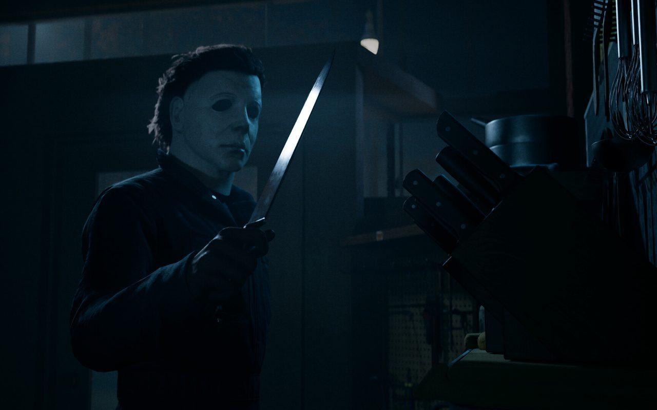 Michael Myers, couteau en main, guette dans l'ombre d'une maison