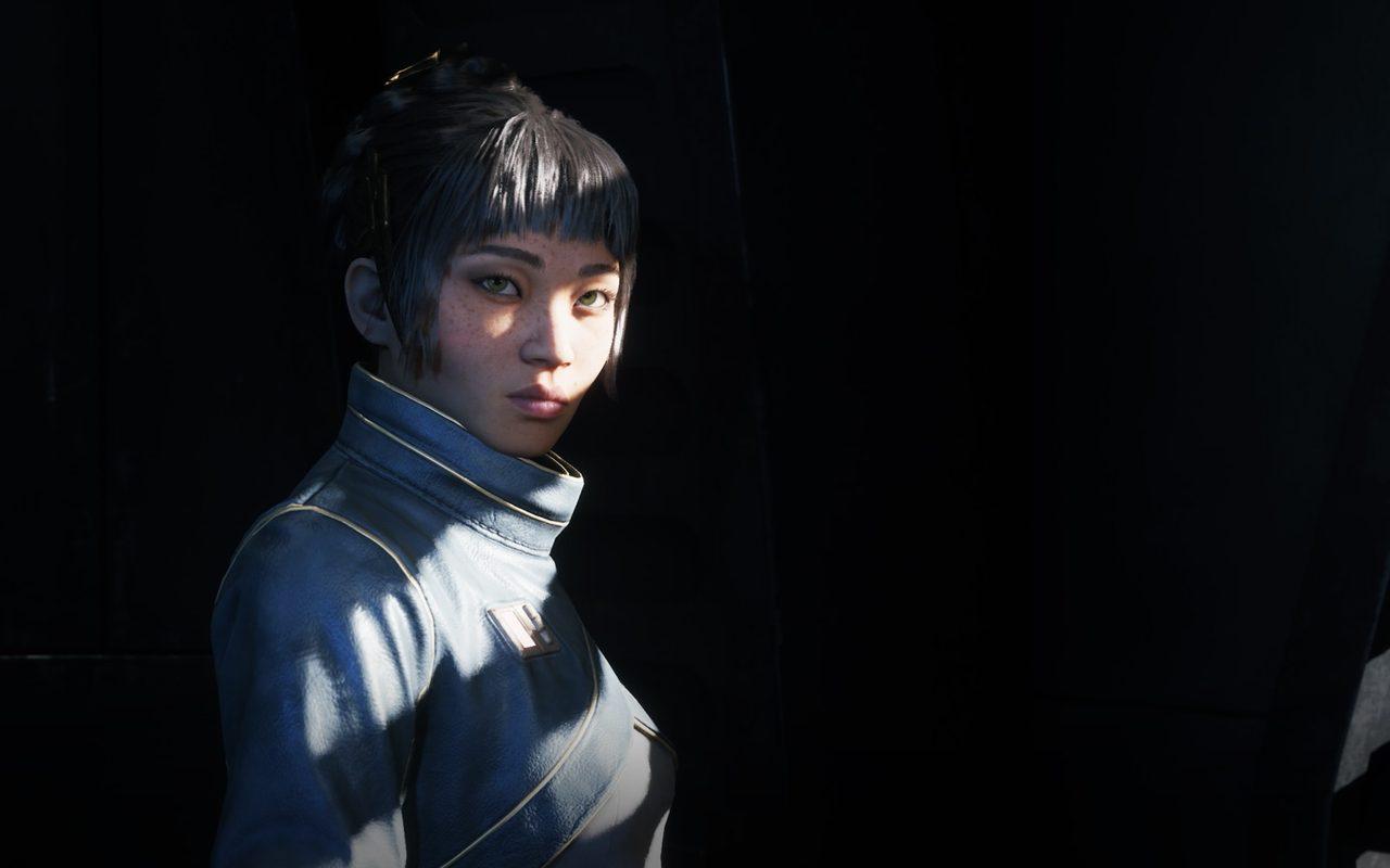 Jae Mordant, jeune officière en uniforme bleu-gris, dans une salle sombre