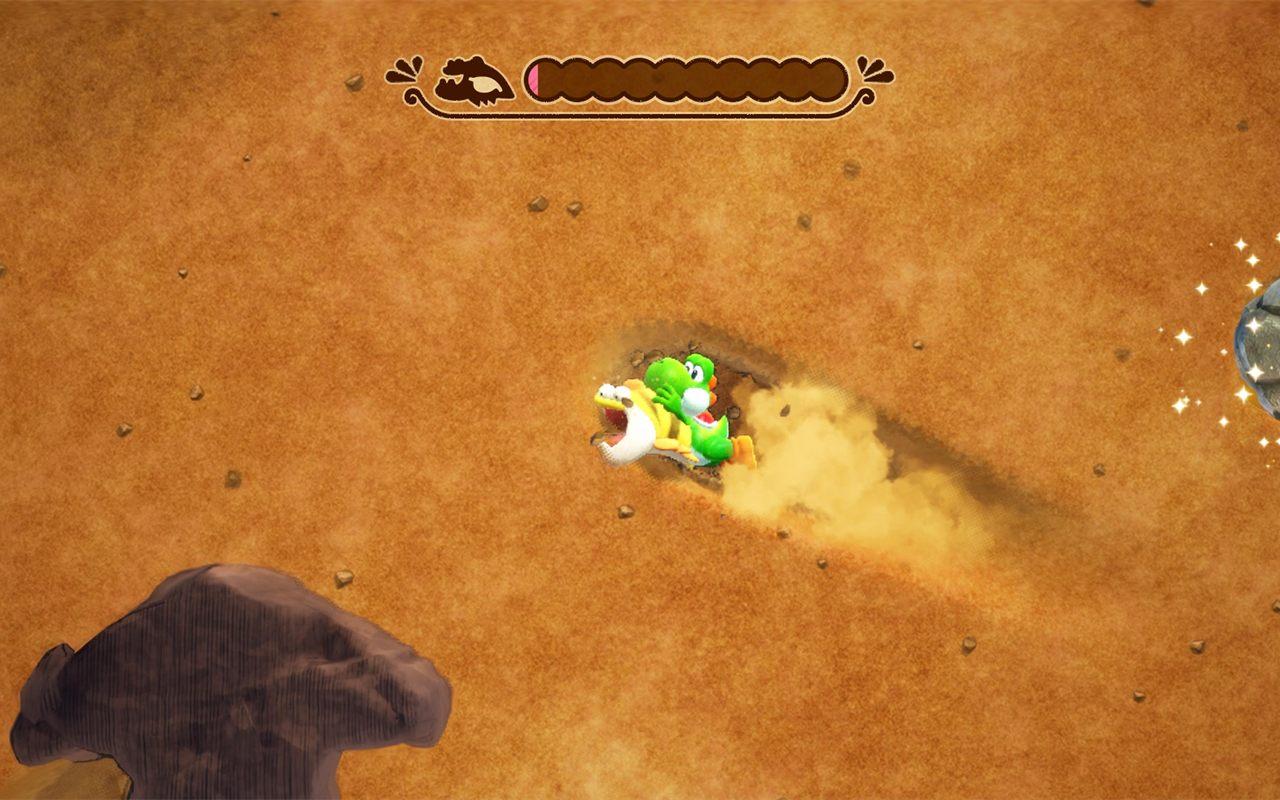 Yoshi creuse un tunnel dans le sable, vu de dessus