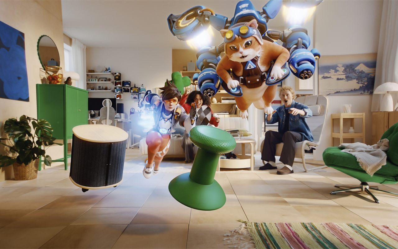 Dans un salon IKEA, des personnages de jeu vidéo surgissent devant des joueurs ébahis, avec le tabouret joystick au premier plan